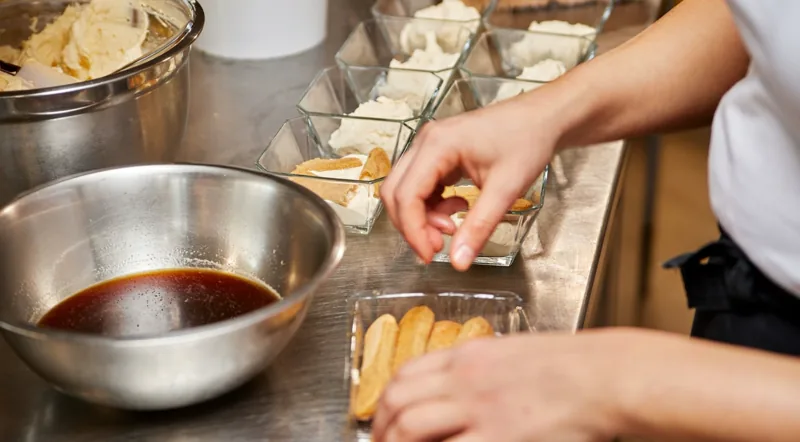 Layering tiramisu with espresso-soaked savoiardi biscuits